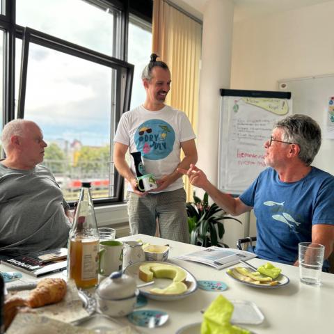 drei Männer an Tisch