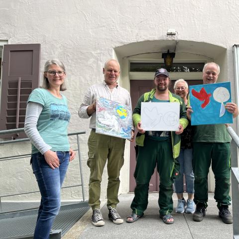 fünf Personen zeigen bemalte Blätter