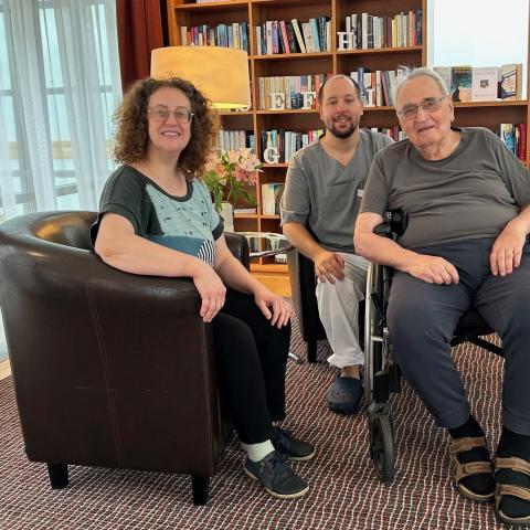 drei Menschen vor einer Bücherwand