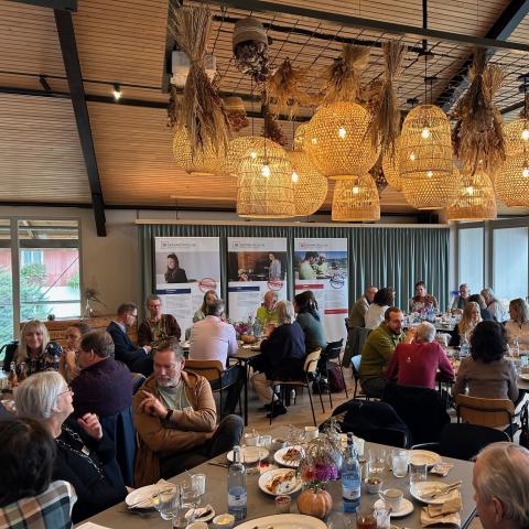 Menschen an Tischen beim Frühstück