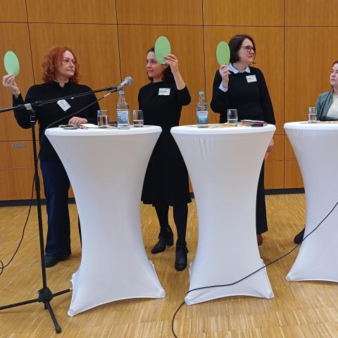 Kandidierende halten rote und grüne Karten hoch - eine Blitzlichtumfrage