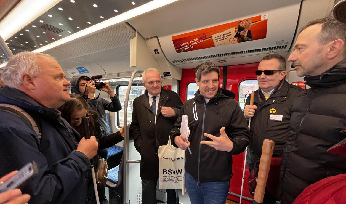 Eine Gruppe von diskutierenden Menschen stehend in der S-Bahn