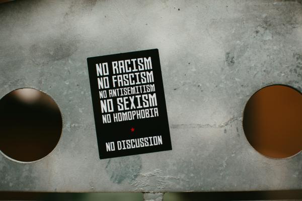 Zettel mit No Racism... auf einem Tisch