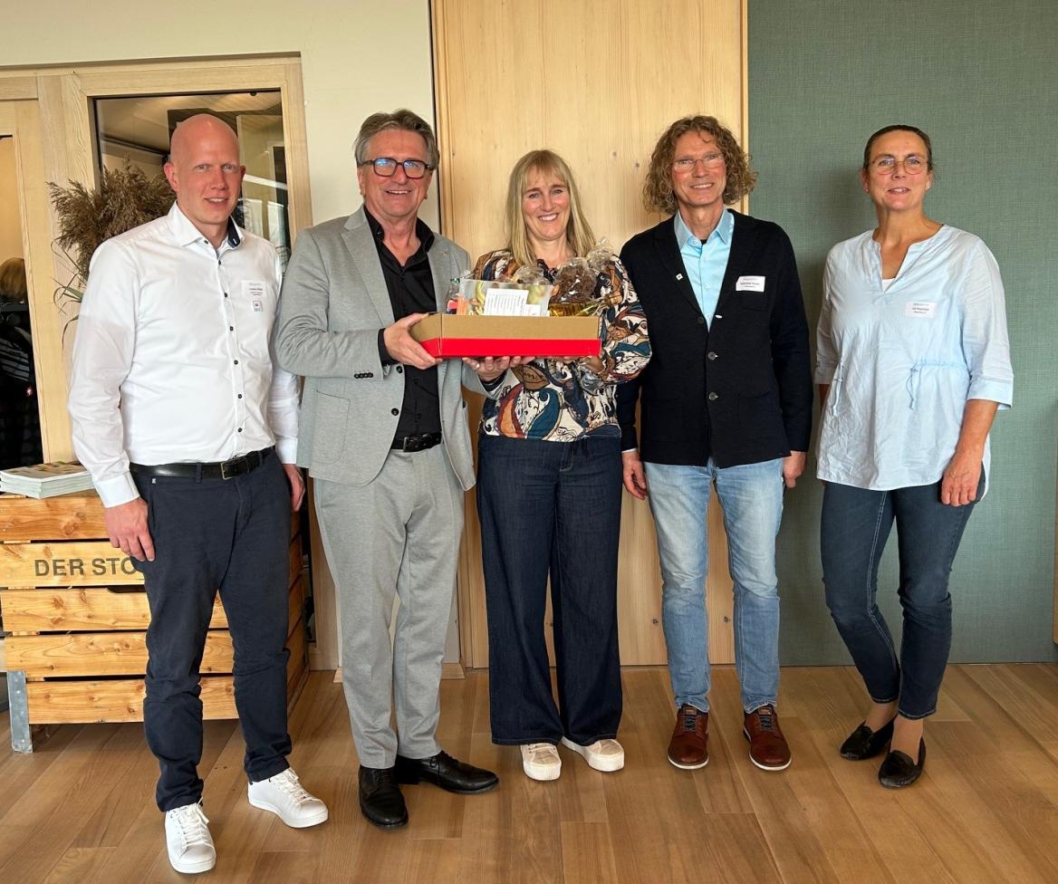 drei Männer und zwei Frauen mit Geschenkkarton