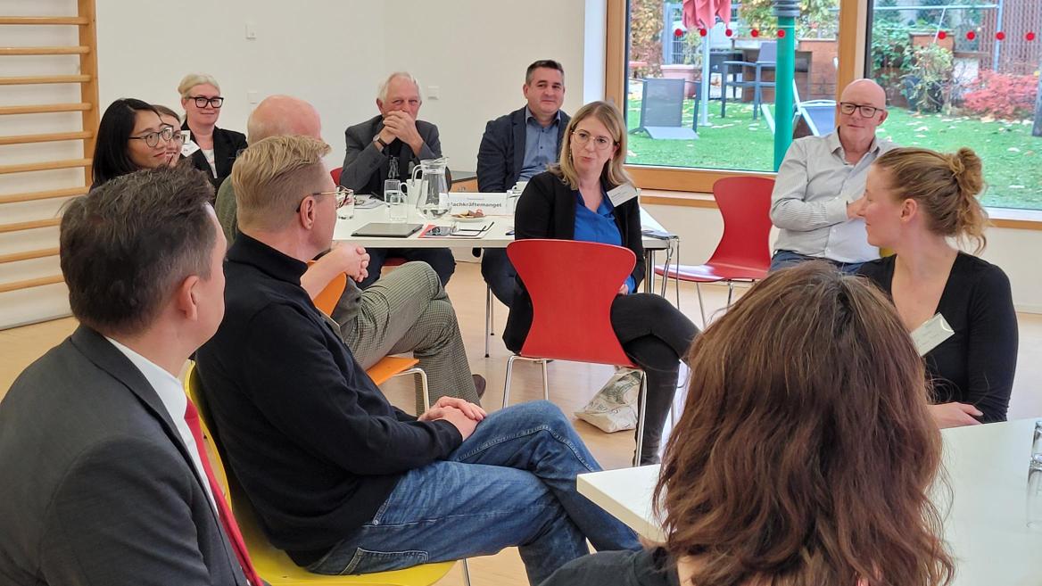 MdB Chantal Kopf (Mitte) und MdB Johannes Fechner (vorne links) diskutieren mit Vertreter*innen Paritätischer Mitgliedsorganisationen