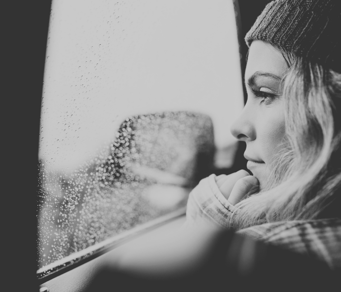 junge Frau schaut aus einem Zugfenster