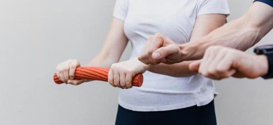 Person mit Hanteln und Strechband