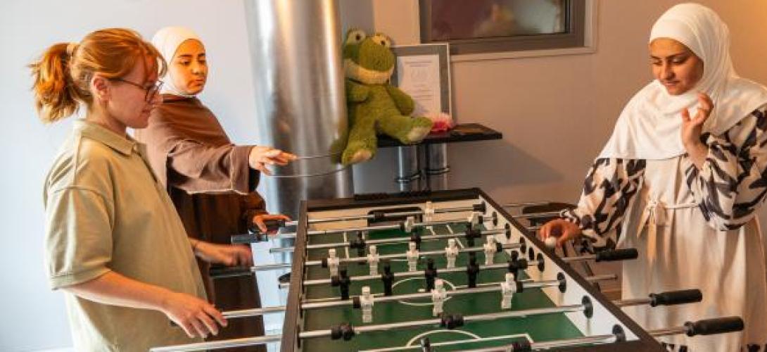 3 junge Frauen spielen Tischkicker