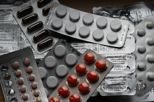 Auf einem Tisch liegen offen verschiedene noch verpackte Tabletten 
