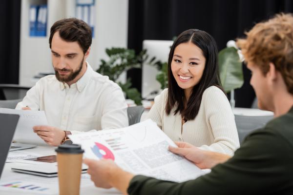 Zwei Männer und eine Frau sitzen am Tisch 