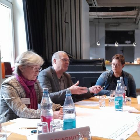 Diskutierende Menschen an einem Tisch