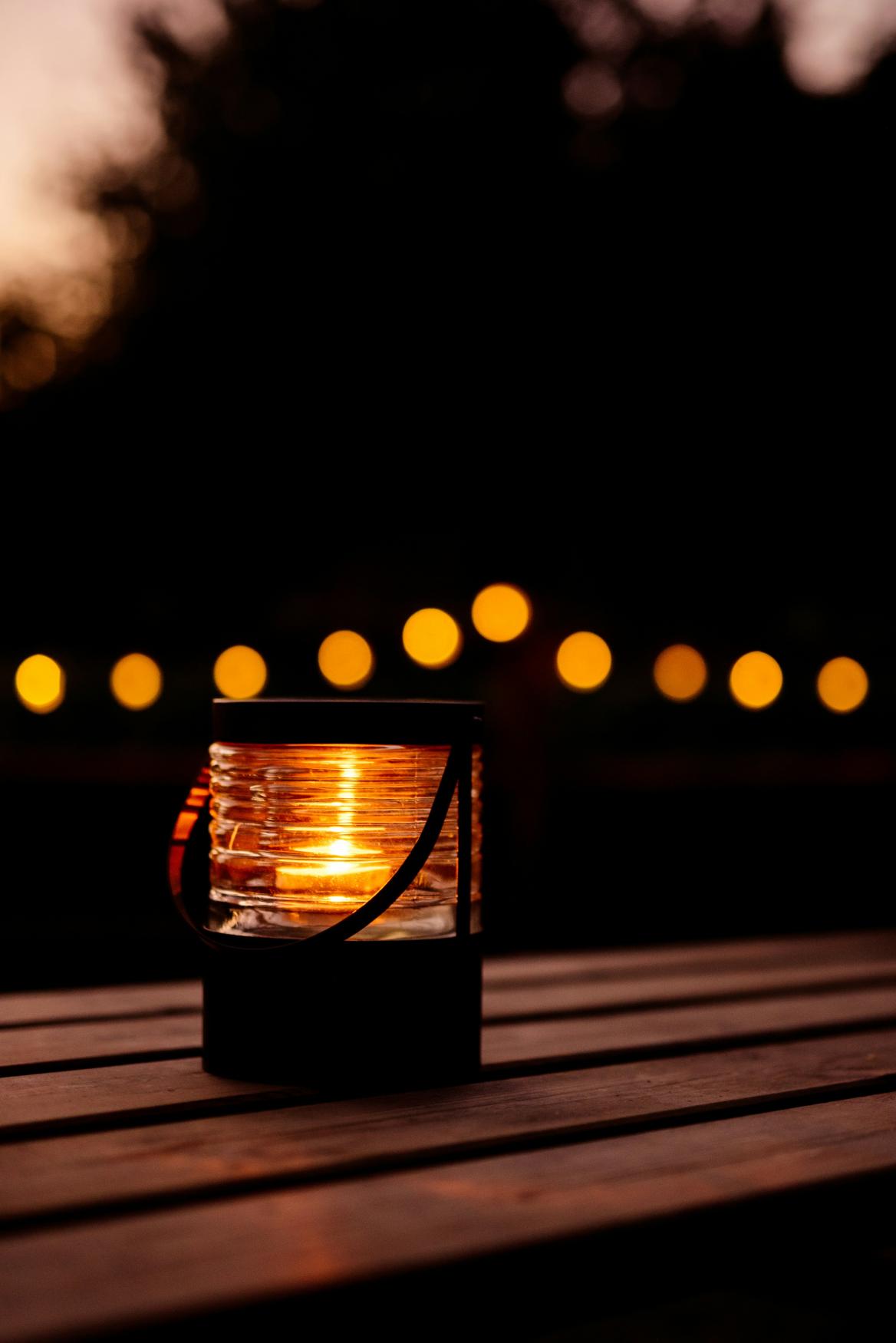Holztisch am Sommerabend mit Lichtern
